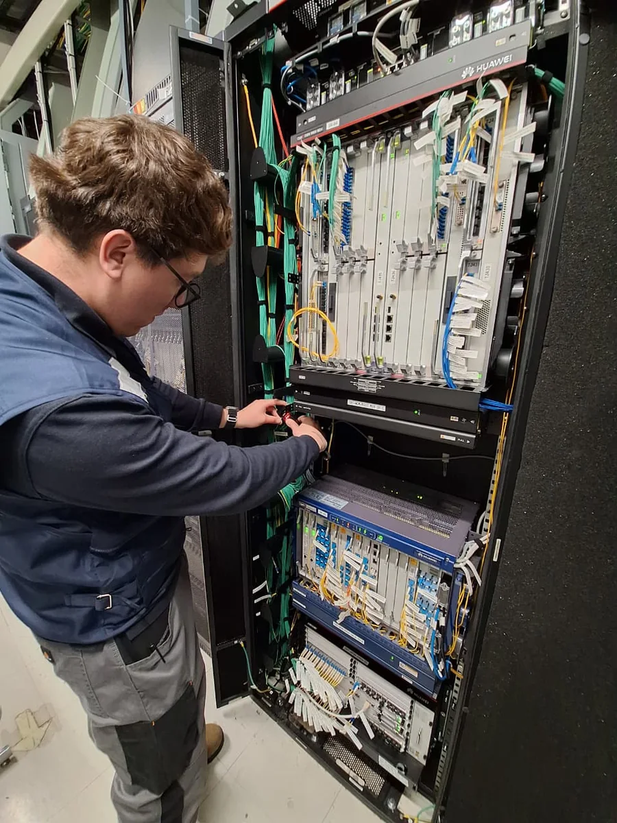 Especialista de Tamatel interviniendo infraestructura de fibra óptica en terreno