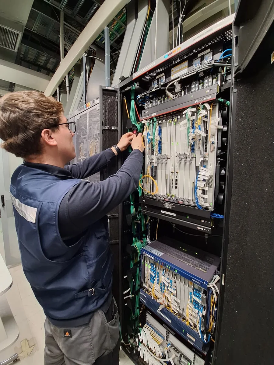 Especialista Tamatel interviniendo un rack de transmisión de fibra óptica