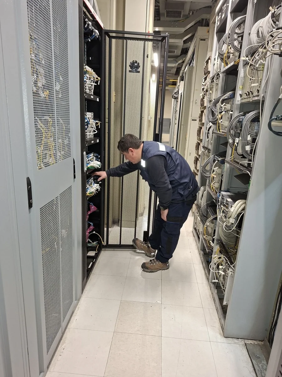Técnico Tamatel operando un gabinete de distribución en sala de equipos